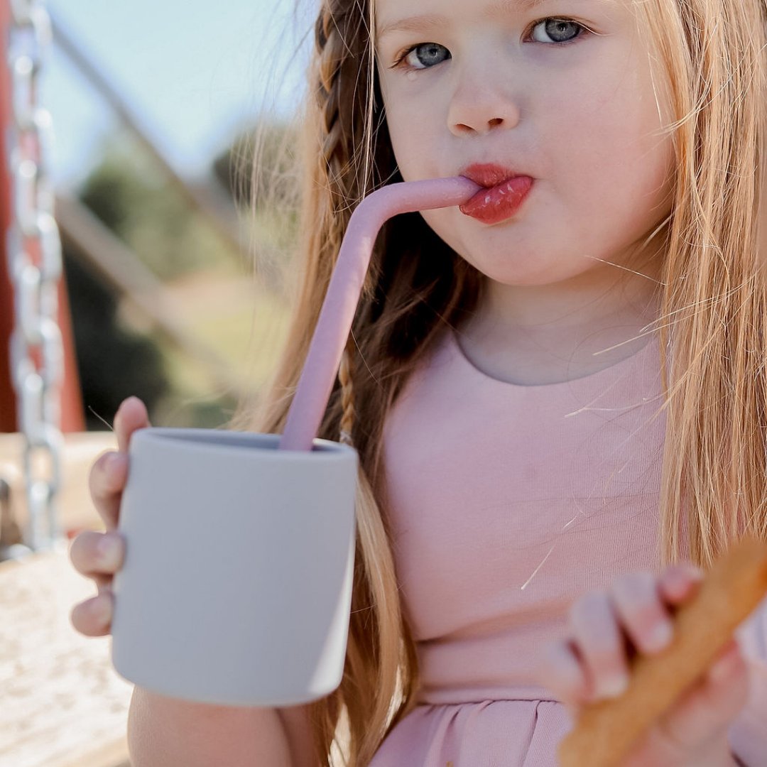 Young girl drinking from silicone cup